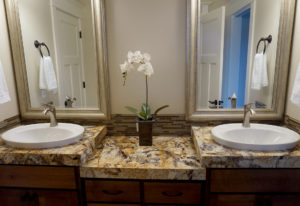 Bathroom vanity with 2 elevated sinks separated by ample counter space.